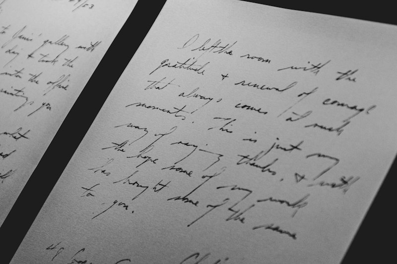 Carta de aniversário para amiga escrita à mão ao lado de um presente e flores