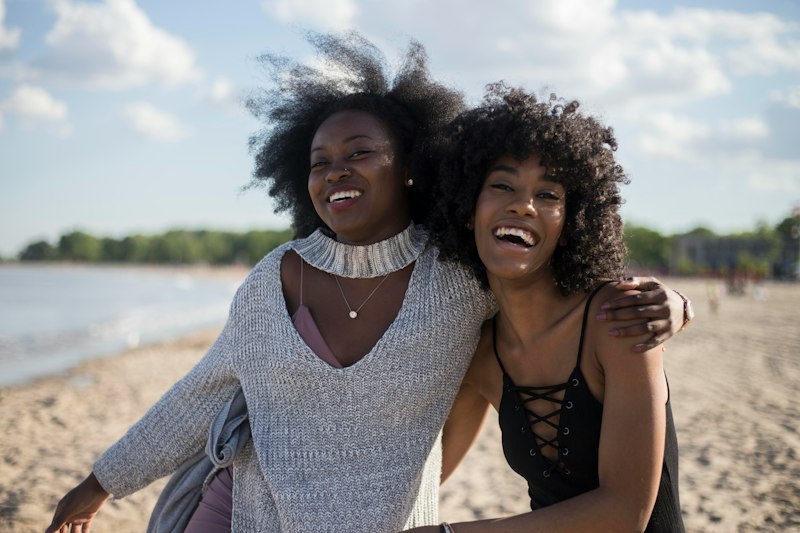 Duas amigas se abraçando e rindo durante uma comemoração de aniversário