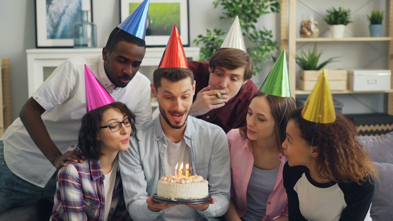 Amigos celebrando um aniversário enquanto um deles lê uma carta