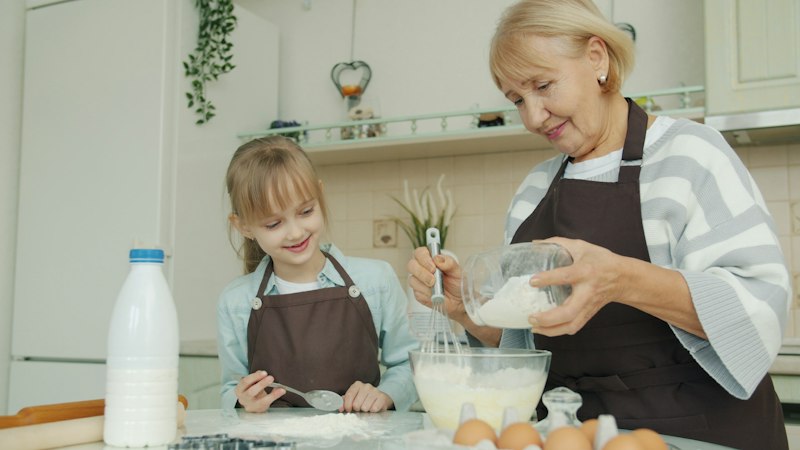 Avó e neta cozinhando juntas uma receita de família