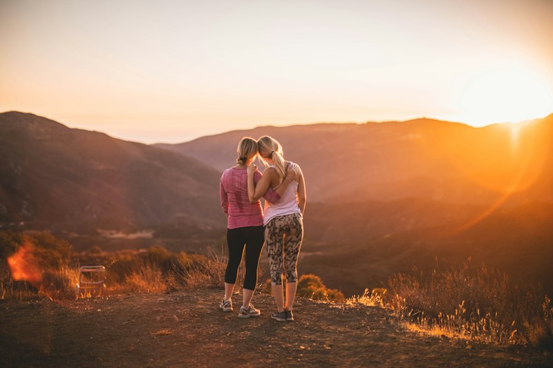 Mãe e filha olhando juntas para o horizonte, simbolizando o futuro