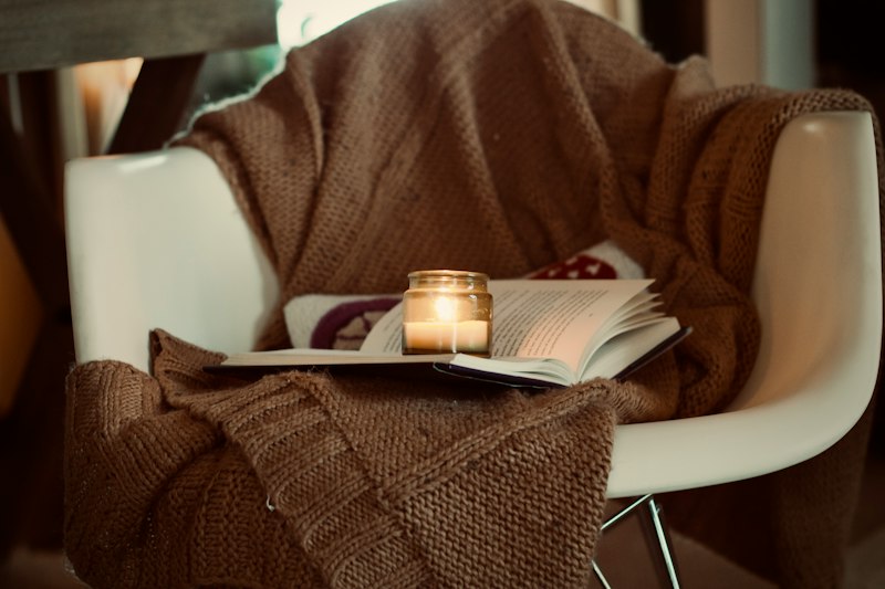 Mesa aconchegante com caderno, vela e caneta, ambiente ideal para escrever uma carta pessoal