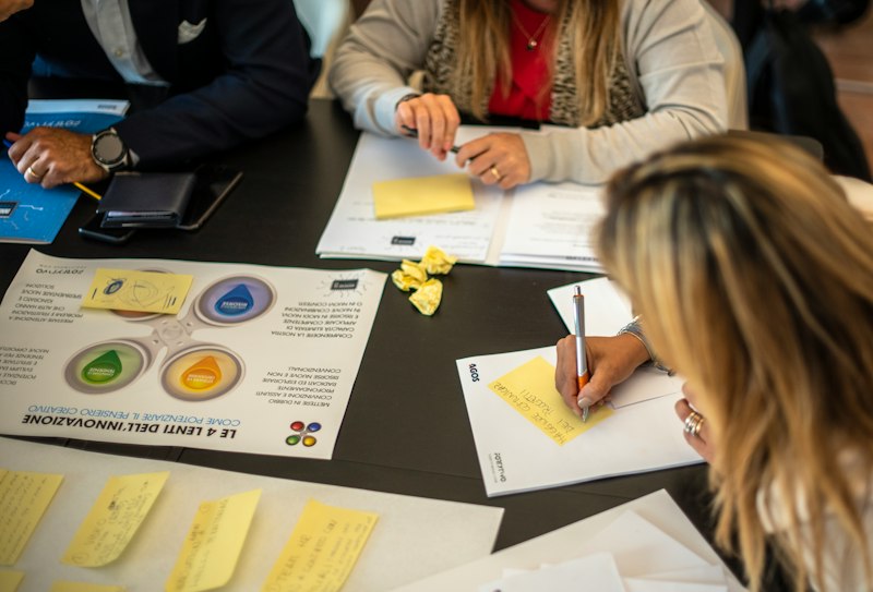 Facilitador conduzindo uma dinâmica de grupo em ambiente acolhedor e colaborativo