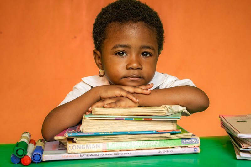 Criança lendo um livro em sala de aula durante a fase de alfabetização