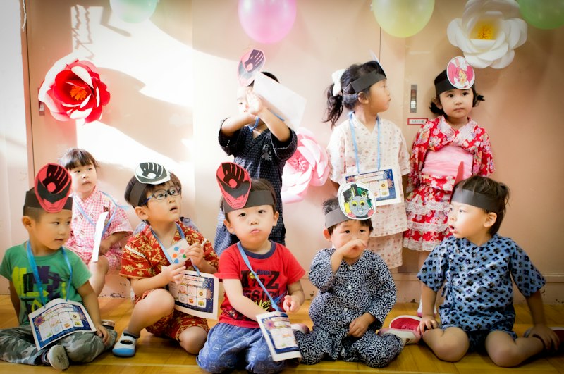 Crianças com capelos celebrando a formatura do ABC na escola