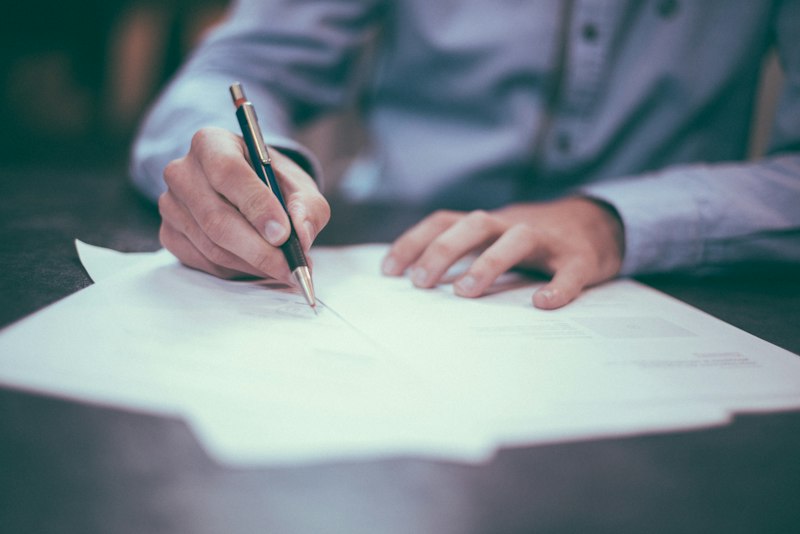 Pessoa escrevendo uma carta à mão, registrando pensamentos e sentimentos para o futuro