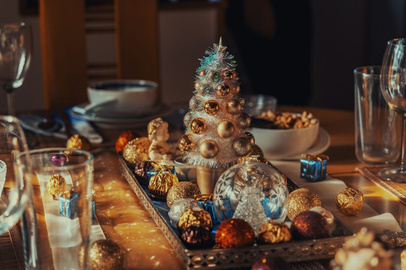 Família reunida em volta da mesa de ceia de Natal compartilhando mensagens