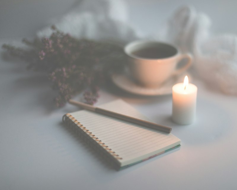 Caderno aberto ao lado de uma xícara de café, pronto para responder perguntas de autoconhecimento