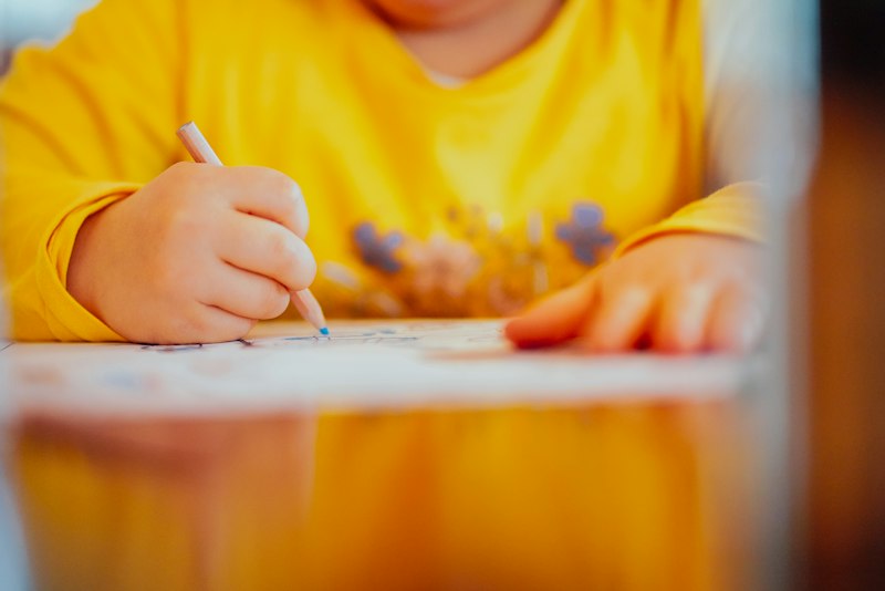 Criança desenhando e escrevendo suas respostas para a cápsula do tempo
