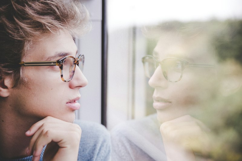Jovem adulto refletindo sobre seus objetivos e planos para o futuro