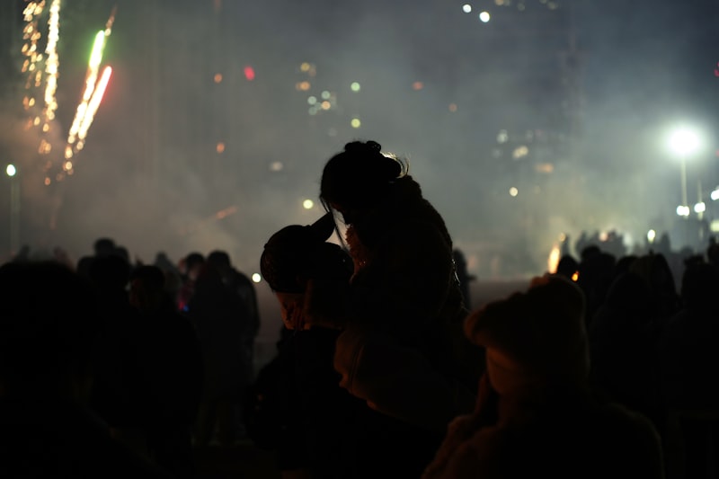 Casal celebrando o Réveillon com fogos de artifício ao fundo