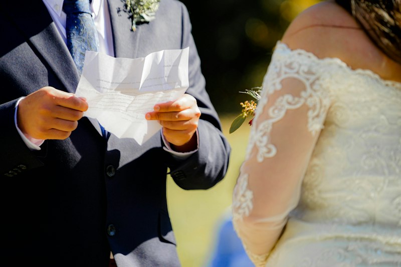 Noiva lendo os votos de casamento para o noivo diante dos convidados
